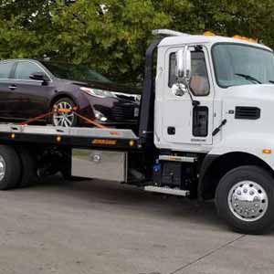 A car being transported on a flatbed towing truck